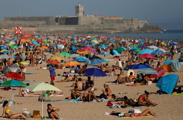 Португалски плаж край Лисабон е претъпкан с хора в жегата. 