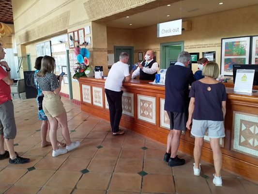 Служител на рецепцията с маска дава напътствия на гостите на блокирания хотел в Тенерифе