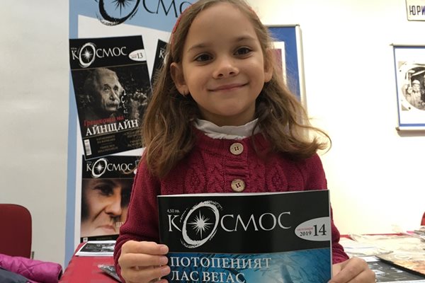 Стефани на 7 години от София позира с предпоследния брой на "Космос", посветен на подводните градове.