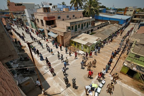 Индийци чакат на разстояние едни от други, за да получат безплатна храна