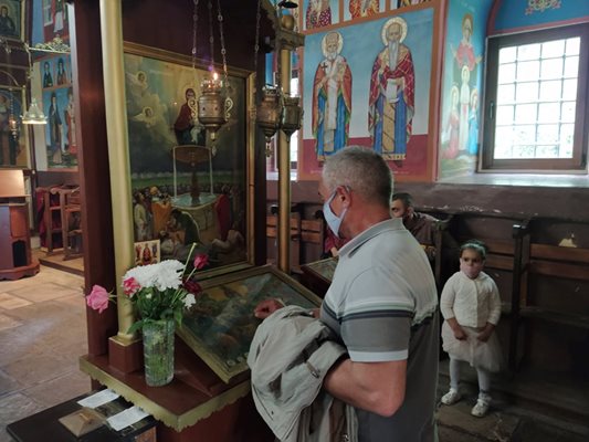 Мъж докосна иконата на светеца, докато се моли.
