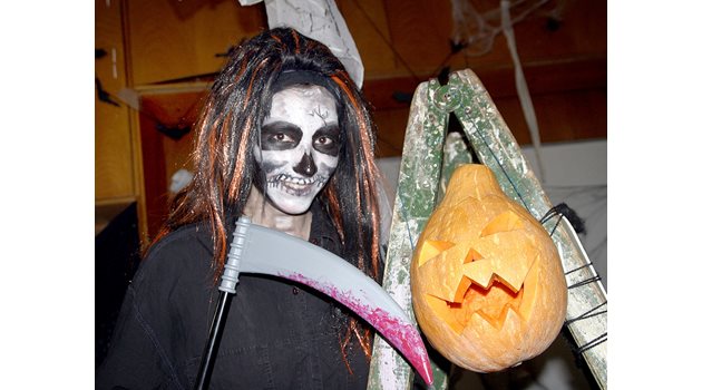 Девойка се е маскирала като вампир с тиква за Хелоуин.