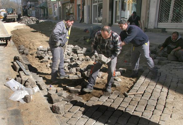 Работници редят паветата по "Отец Паисий", която претърпява пълна реконструкция.