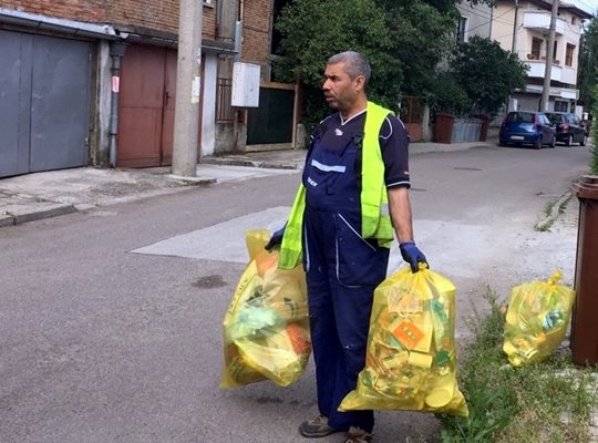 Работник на "Чистота" изнася отпадъци от опаковки в кв. "Коматево".