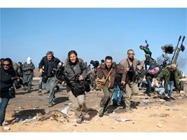 Журналисти бягат от въздушни удари край Рас Лануф на 11 март. Вдясно с очила е Тайлър Хикс, а крайната вляво - Линси Адарио. Те са двама от четиримата изчезнали американски репортери.
