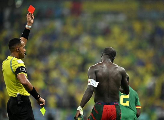 Американският рефер от марокански произход Исмаил Елфат показва червен картон на камерунеца Винсент Абубакар. Преди това той му вдигна втори жълт заради свалянето на фланелката след победния гол срещу Бразилия.