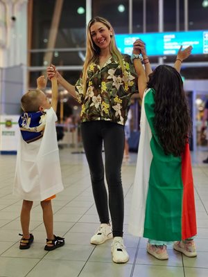 Миг на върховна радост на летище София заедно с щастливи малчугани, дошли да посрещнат своята кака героиня, обгърнати в знамена на България и Петрич. СНИМКА: НАЙДЕН ТОДОРОВ