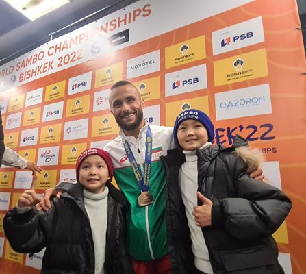 Деца от Киргизстан се снимат с българския медалист.