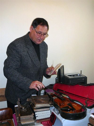 Шефът на шуменската полиция главен комисар Любомир Христов показва цигулката и книгите, иззети при акцията. СНИМКА: Венци Венков