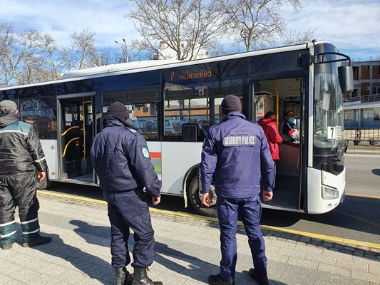 Полицаи оглеждат автобуси за пътници без маски.