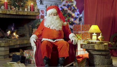 Дядо Коледа седи до камината и дава съветите си към детето.