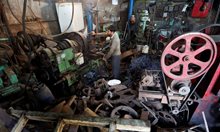 Роаботник във фабрика за индустриални тръби в Мумбай, Индия