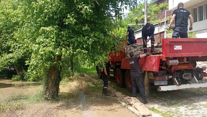 Пожарникари градят дига с чували пясък