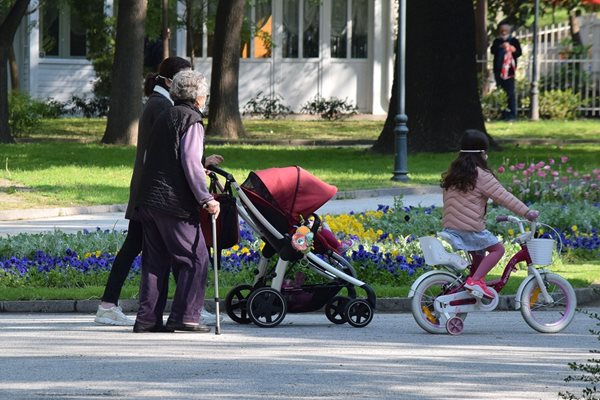 Млада майка и възрастна жена се разхождат на въздух с децата.