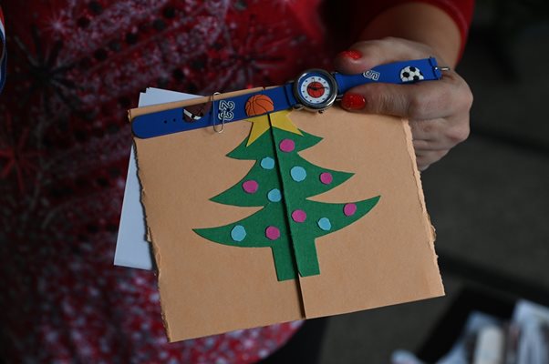 На картичката с елхата детето е прикачило часовник, подарък за Дядо Коледа.