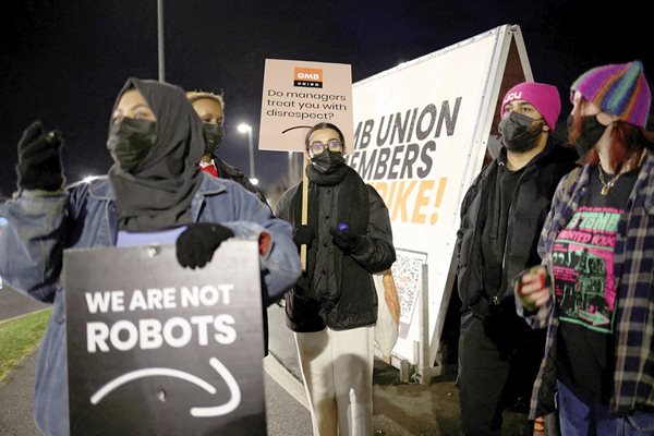 Хора държат плакати с надписи “Ние не сме роботи” на митинг в подкрепа на стачкуващите работници на “Амазон” в Ковънтри, Великобритания.
СНИМКА: РОЙТЕРС