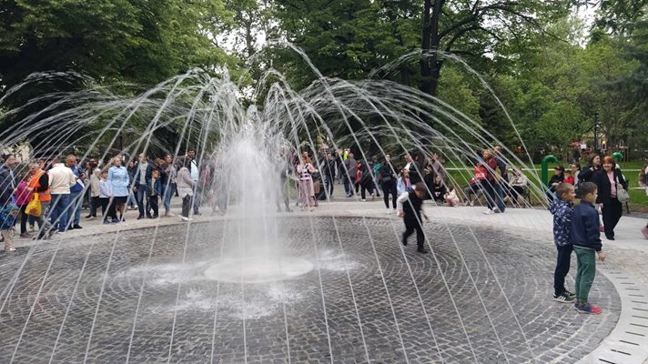 Children run under the dry fountain.