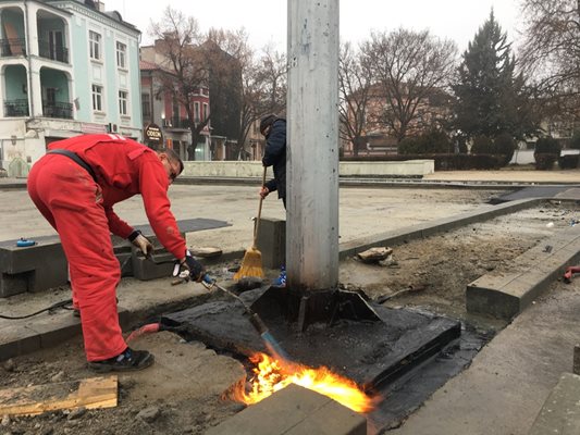 С газови горелки спояват хидроизолацията около основите на стълбовете, които бяха махнати, а след това върнати.