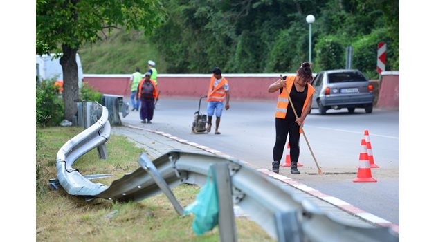 Служителки от чистотата метат пътя след катастрофата край Своге на 25 август.