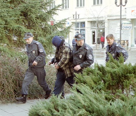 Полицаи водят Атанас Божинов към мястото, където е хвърлил пистолета "Берете" през  2003 г.