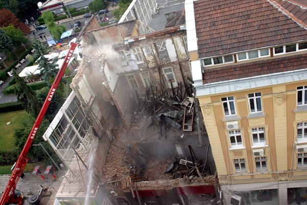 Така изглежда сградата около час след рухването и?. На снимката вдясно полицаи и пожарникари вадят телата на двете момичета.