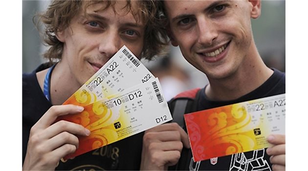 ЦЕННИ ХАРТИИ: Млади англичани показват копия на билетите, които се разиграват с лотария за желаещите да наблюдават на живо състезанията от олимпийските игри.