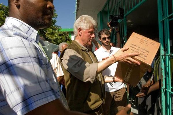 Бившият американски президент Бил Клинтън разтоварва помощи пред болница в Порт-о-Пренс.
