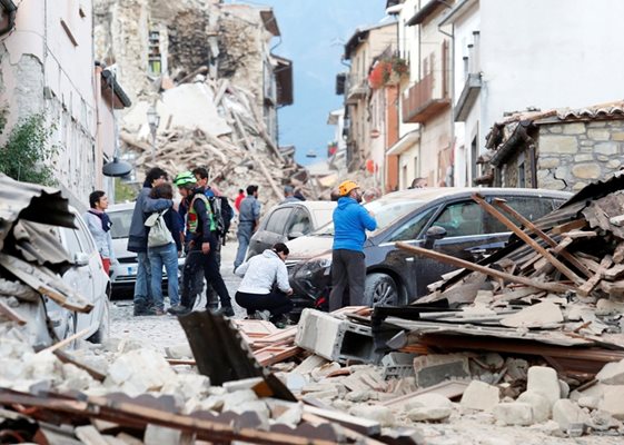 Жители на разрушения град Аматриче са се събрали на улица, затрупана от руини.