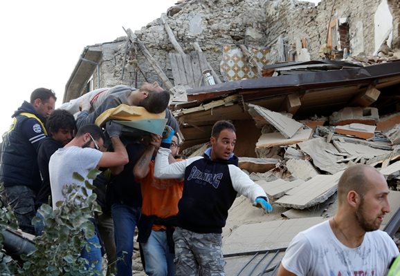 Спасители носят мъж, изваден жив от руините след опустошителния трус в Аматриче.