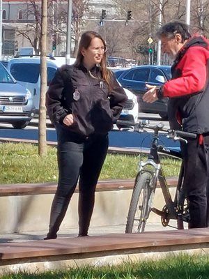 Служителка на "Общинска охрана" предупреждава колоездач.