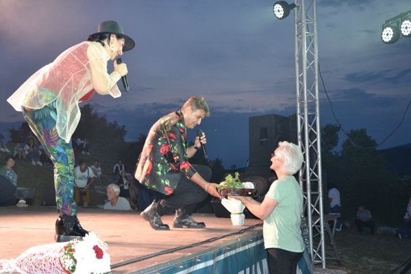 Възрастна момчилградчанка дари тракийска баница на Катя и Здравко от дует "Ритон", докато пееха на сцената край светилището на Орфей. СНИМКА: НЕНКО СТАНЕВ