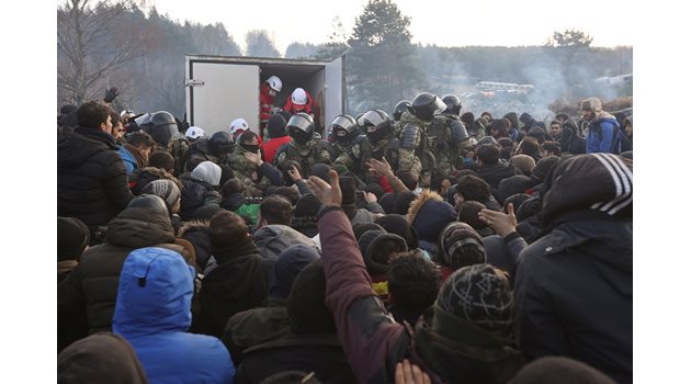 Мигранти на границата между Полша и Беларус чакат за разпределение на хуманитарна помощ.

