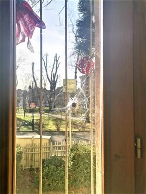 Дупката от стрелбата ясно личи на един от прозорците в къщата.