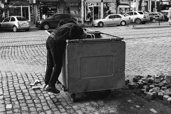 Мъж е принуден да рови в боклука, за да намери нещо за ядене или вещ, която може да му потрябва.
