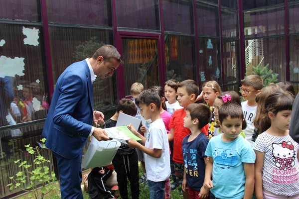Димитър Колев раздава книжки на хлапетата.