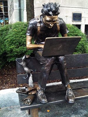 Статуя на студент с компютър на пейка в центъра на Монреал