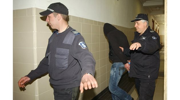Петър Стоянов крие лицето си на път за съдебната зала.