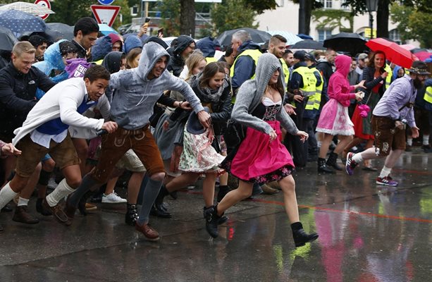 Гости на бирения фестивал бягат под дъжда, за да заемат места в палатките.