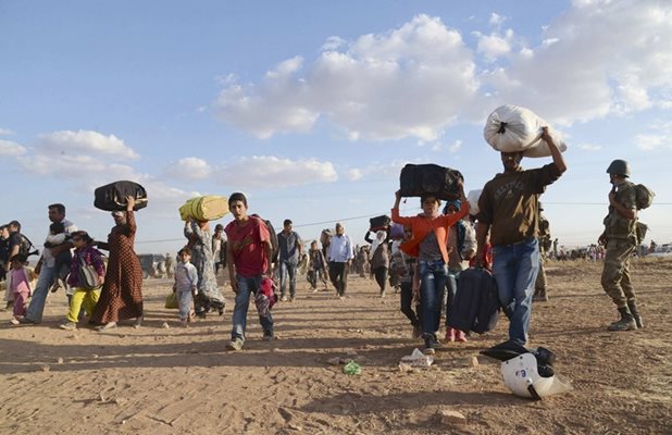 Сирийски кюрди, носещи вещите си, преминават границата от Сирия в Турция, бягайки от настъпващите джихадисти.