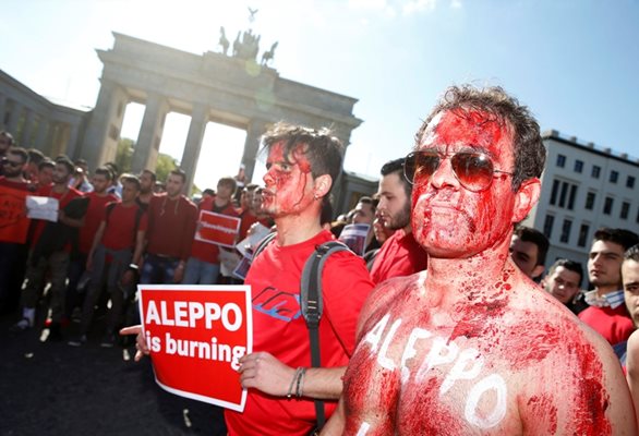 Демонстранти боядисаха телата си с червена боя пред Бранденбургската врата в Берлин в знак на солидарност с народа на Алепо заради кървавите сражения в сирийския град.