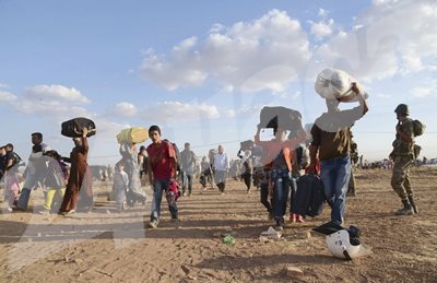 Сирийски кюрди, носещи вещите си, преминават границата от Сирия в Турция, бягайки от настъпващите джихадисти.