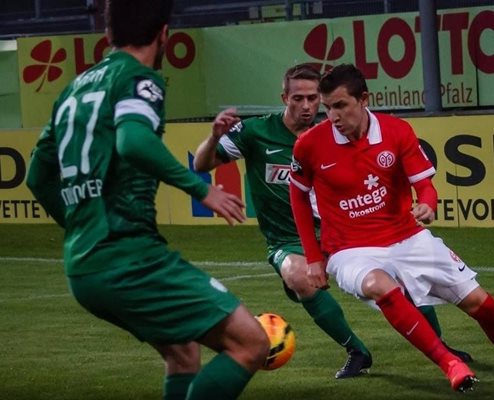 Националът Тодор Неделев се шмугва между двама футболисти на “Пройсен” (Мюнстер) при победата на втория състав на “Майнц 05” с 4:0 в среща от III лига на Германия.