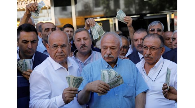 Бизнесмени, които притежават щатски долари, стоят пред чейнджбюро в отговор на призива на президента Реджеп Ердоган към турците да продадат спестяванията си в долари и евро, за да подкрепят лирата в Анкара.  СНИМКА: РОЙТЕРС