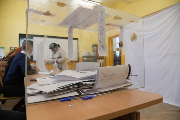 Избирателка показва личните си документи, преди да влезе да гласува в тъмната стаичка. СНИМКА: Йордан Симеонов