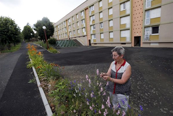 РОЙТЕРС

Жена сади цветя пред социално жилище във Франция.