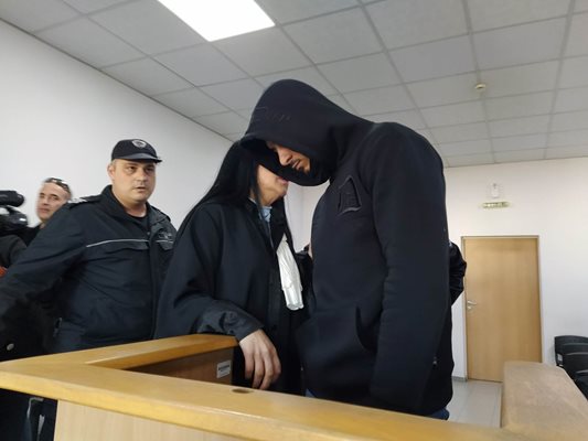 Адвокат Надежда Римпева консултира на ухо своя клиент Денислав Борисов в съдебната зала.