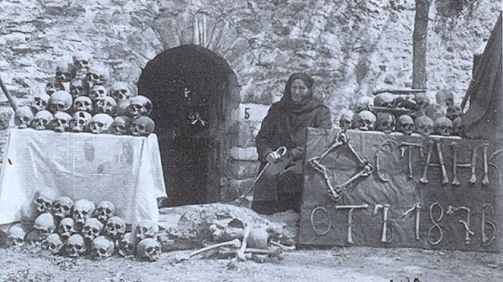 Марга Горанова, оцеляла след Баташкото клане, пред входа на църквата, където е извършено клането. С кости е написано - Останки от 1876 г.