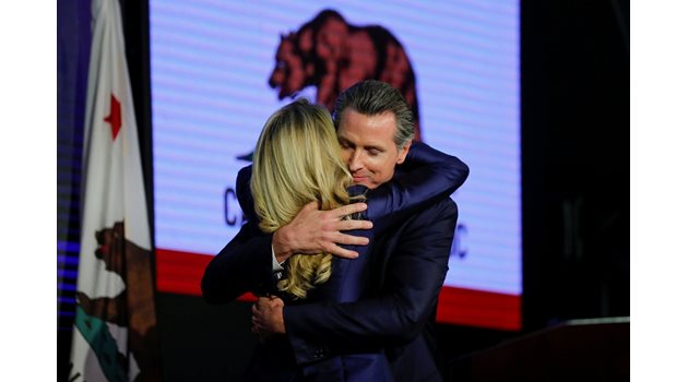 Демократът Гавин Нюзумом прегръща жена си, след като спечели губернаторския пост в Калифорния.