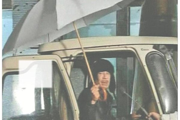 Либийският лидер Муамар Кадафи се появи по телевизията, седнал в кола и разтворил чадър. Той обяви, че не е напускал страната. СНИМКИ: ДЕСИСЛАВА КУЛЕЛИЕВА И РОЙТЕРС

