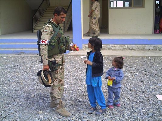 Наш медик разговаря с дете на улицата в Афганистан по време на мисия в размирната страна. 
